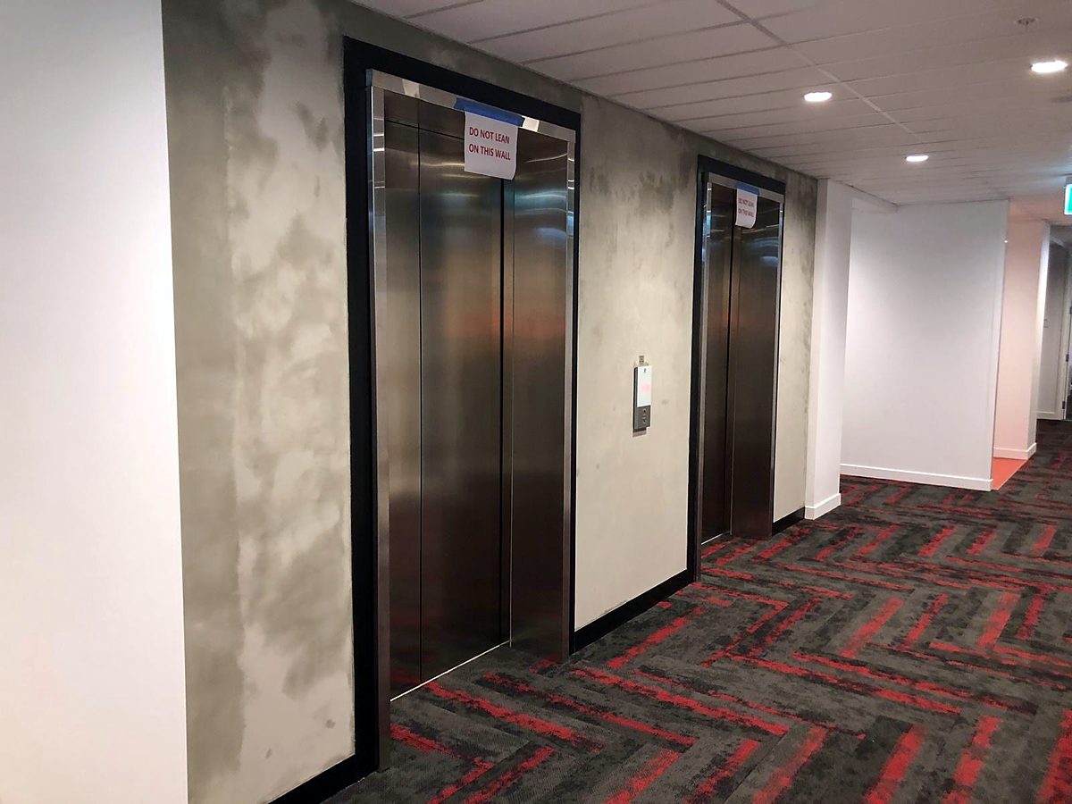 Concrete-look finish continuing along an office corridor