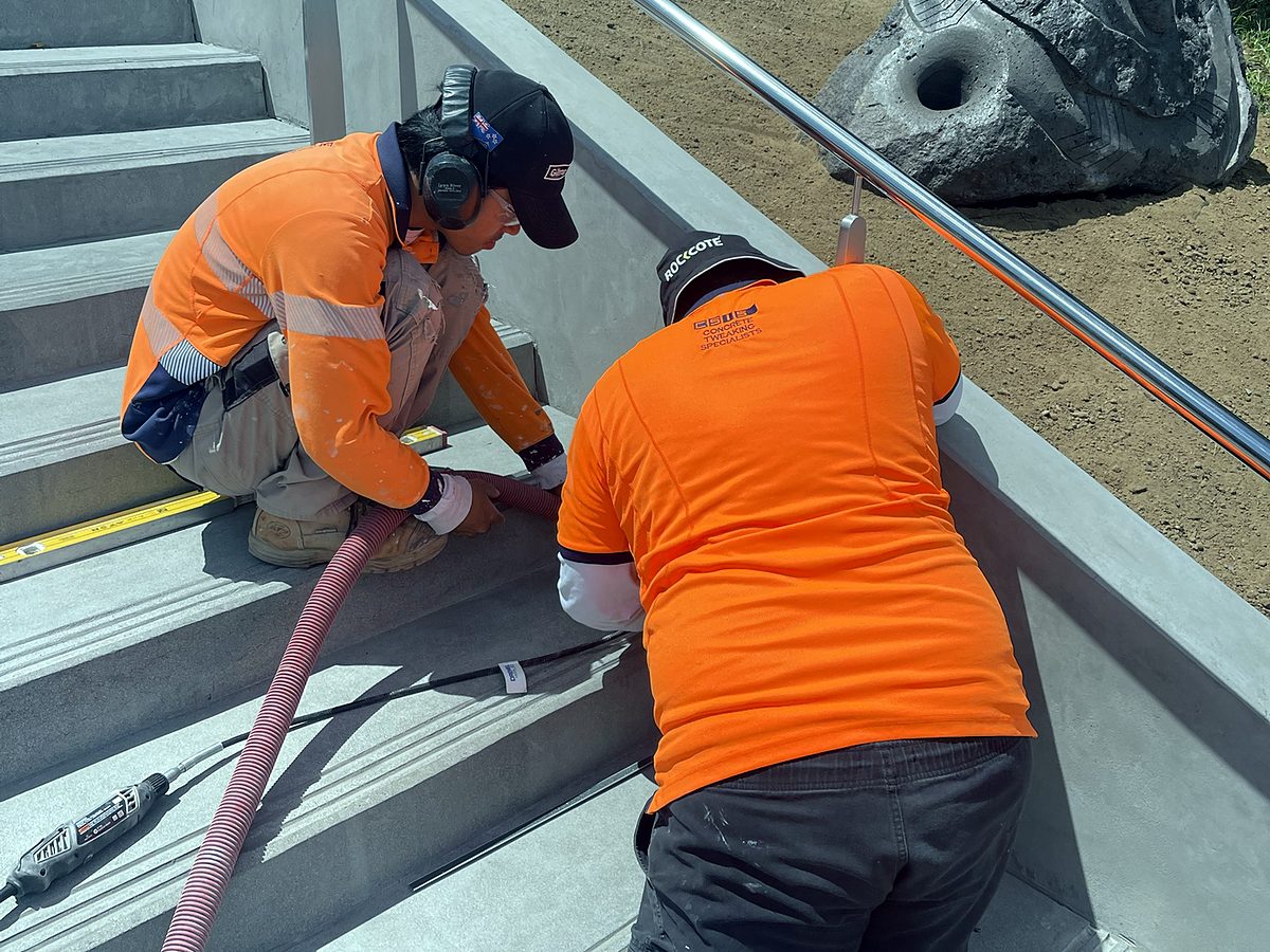 Two CSIS team members preparing a stair tread