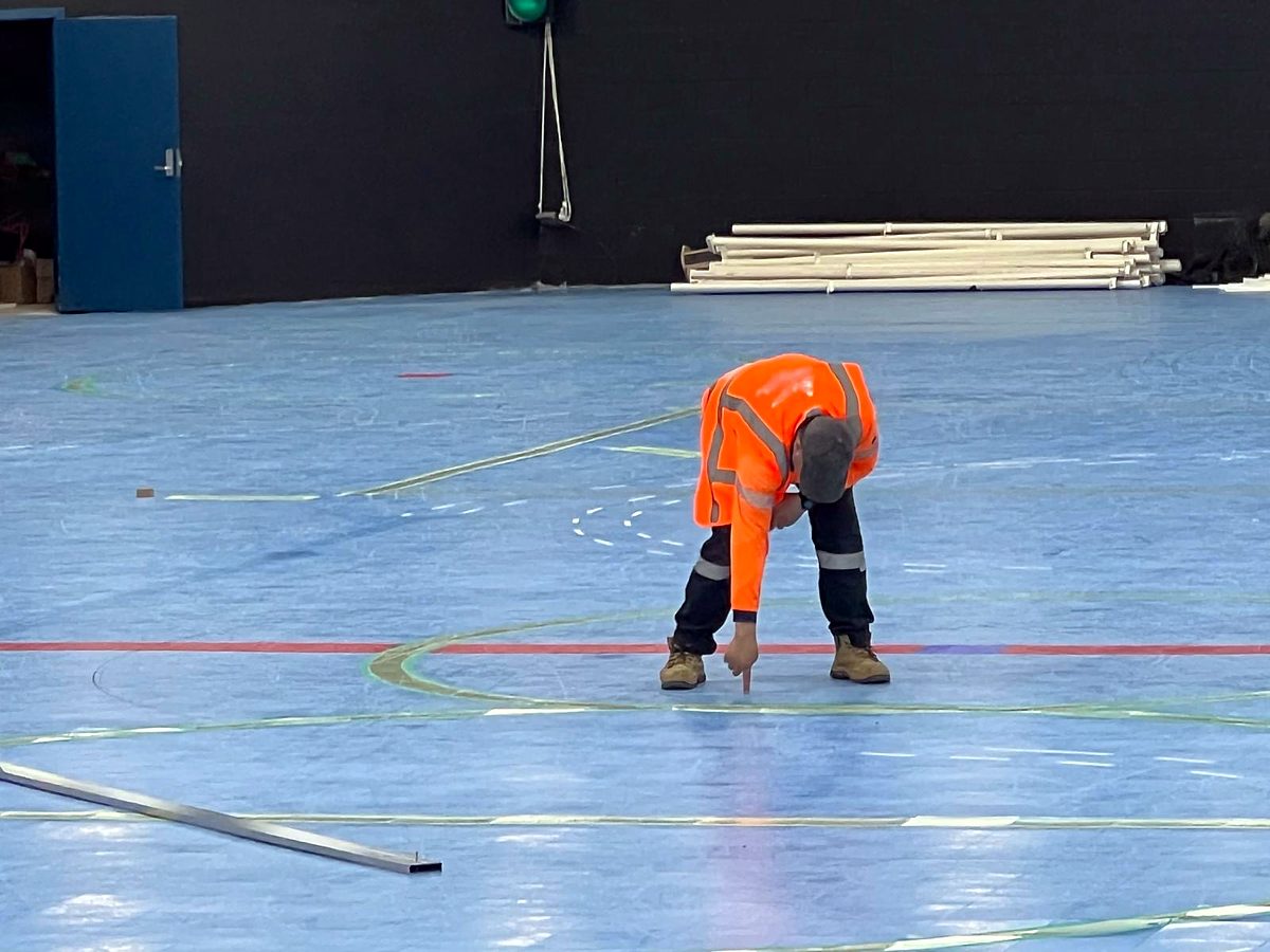 Team member marking out a line on the floor