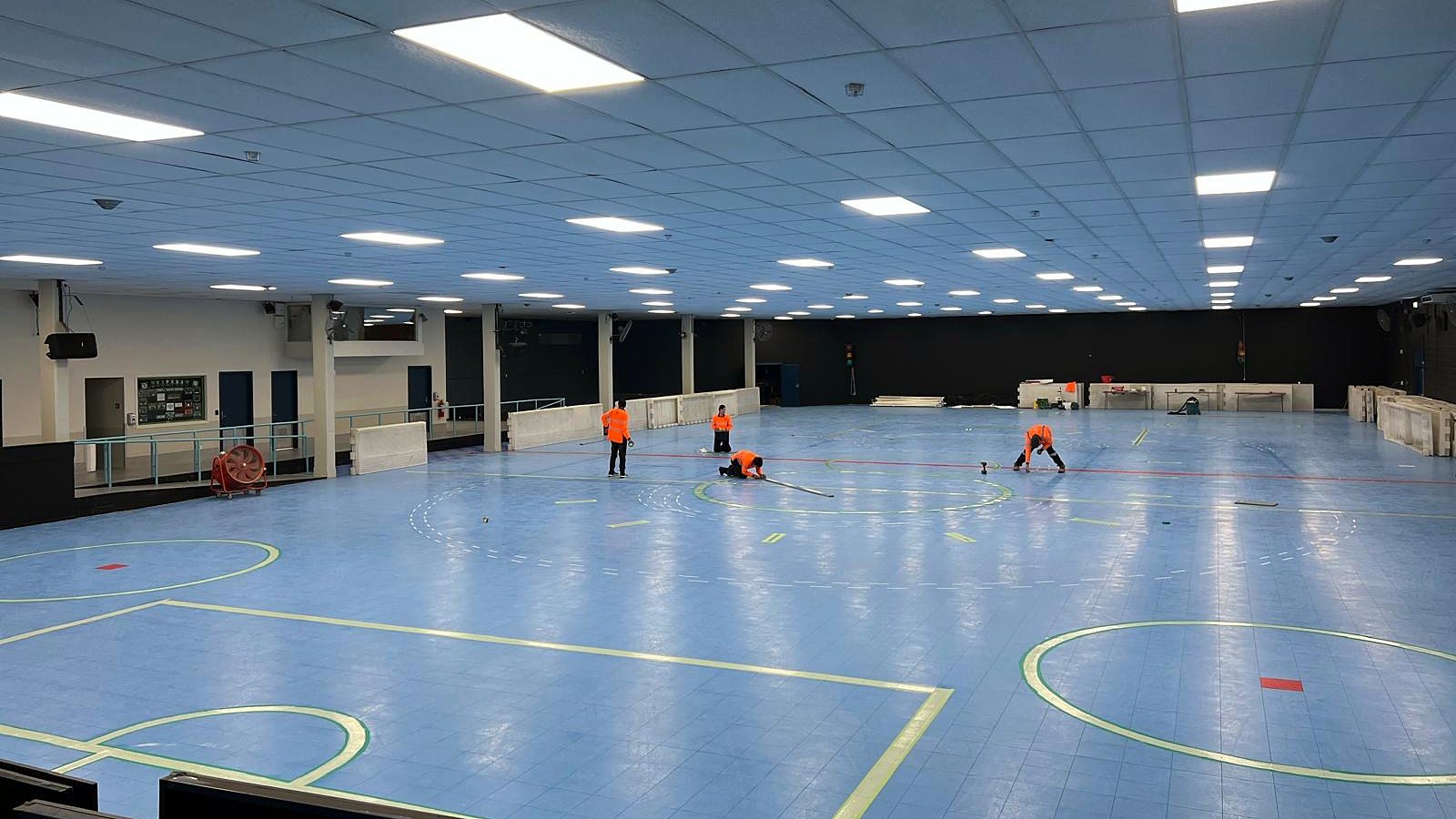 CSIS team setting out court markings across the sports hall