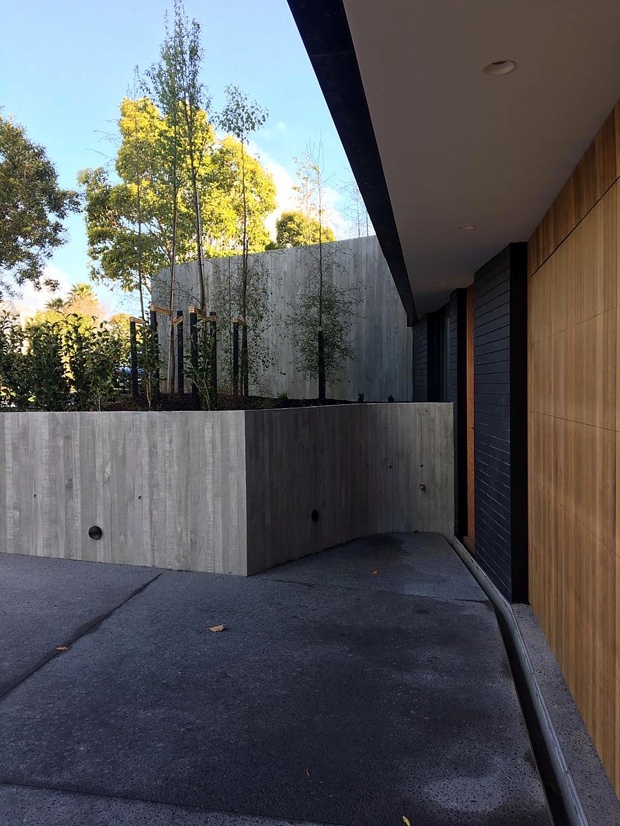 Board-formed concrete retaining wall at a new Auckland home