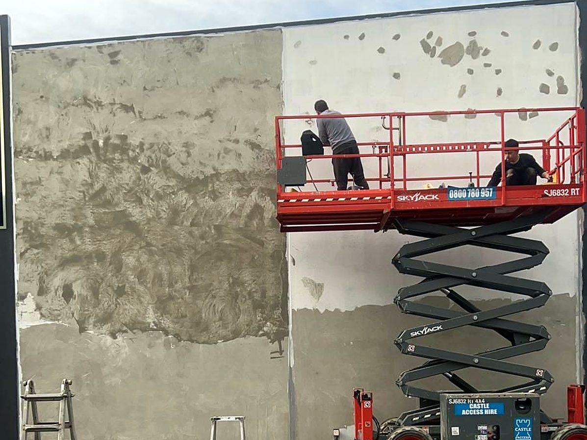 Skim coat being applied from a scissor lift